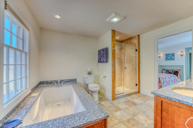 full bathroom featuring a shower stall, toilet, vanity, a bath, and ensuite bath