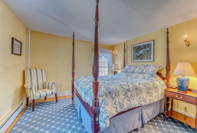 bedroom featuring baseboards, baseboard heating, and wood finished floors