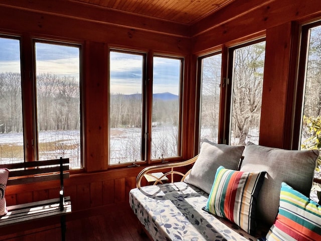 sunroom / solarium featuring a mountain view and wooden ceiling