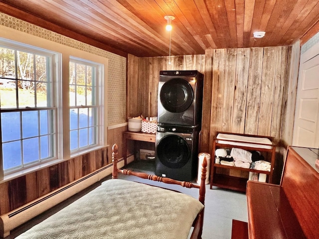 washroom featuring a baseboard heating unit, wood walls, laundry area, wooden ceiling, and stacked washer / drying machine