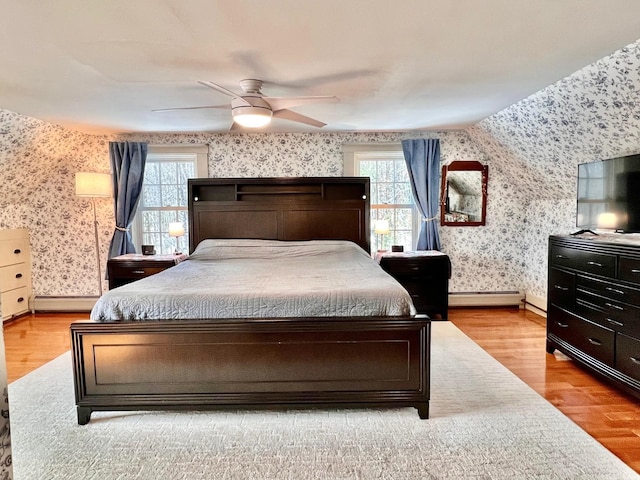 bedroom featuring multiple windows, wallpapered walls, baseboards, and wood finished floors