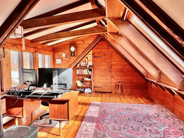 office space with lofted ceiling with beams, wooden walls, and hardwood / wood-style flooring