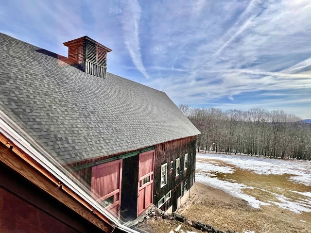 view of property exterior with roof with shingles