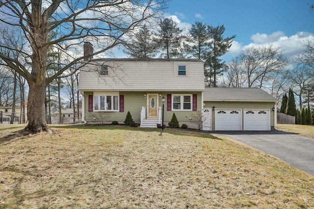 colonial inspired home with fence, a garage, driveway, and a chimney