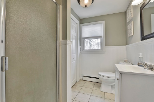 bathroom featuring tile patterned floors, toilet, a stall shower, wainscoting, and a baseboard radiator