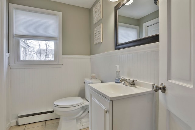 half bath with vanity, a wainscoted wall, a baseboard radiator, tile patterned flooring, and toilet