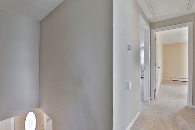 hallway with light carpet, attic access, baseboards, and a baseboard radiator