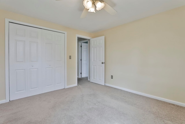 unfurnished bedroom featuring a closet, light colored carpet, baseboards, and ceiling fan