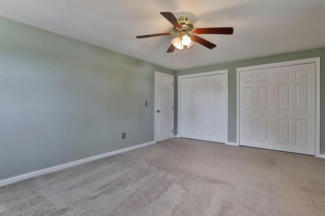 unfurnished bedroom with baseboards, multiple closets, and carpet floors