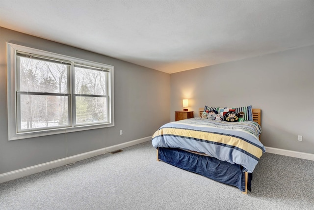 carpeted bedroom featuring visible vents and baseboards