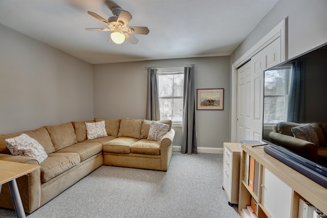 living room with light carpet, baseboards, and ceiling fan