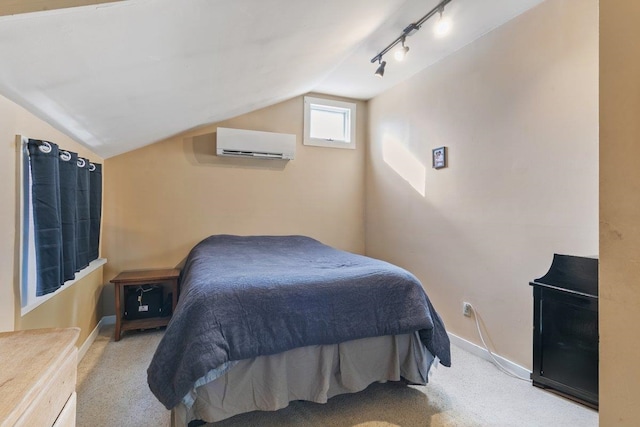 carpeted bedroom featuring baseboards, lofted ceiling, track lighting, and a wall mounted AC