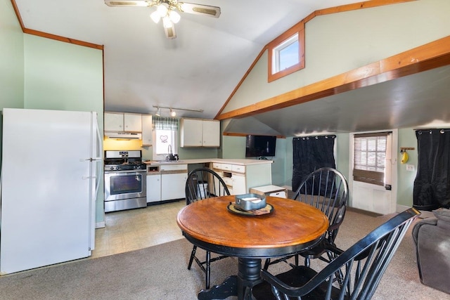 dining area with track lighting, high vaulted ceiling, light floors, and light carpet