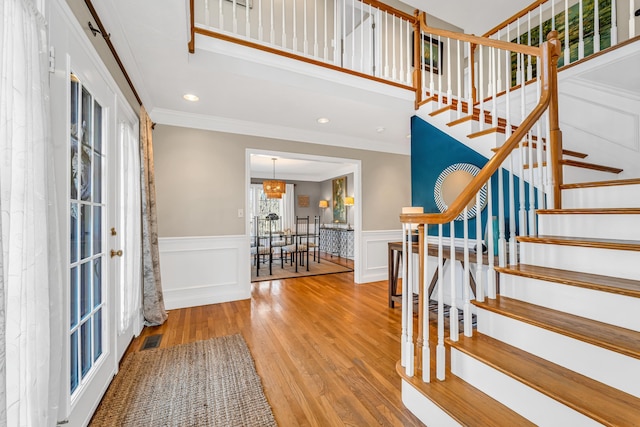 foyer entrance with visible vents, crown molding, stairs, recessed lighting, and wood finished floors