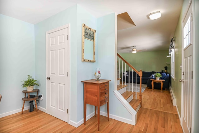 entryway featuring light wood-style flooring, stairs, and baseboards