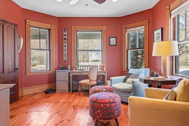 sitting room with light wood finished floors, a ceiling fan, and baseboards