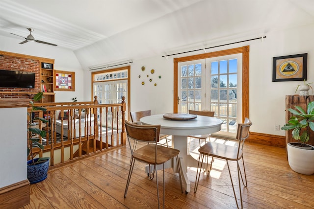 dining room featuring hardwood / wood-style flooring, a ceiling fan, baseboards, and vaulted ceiling