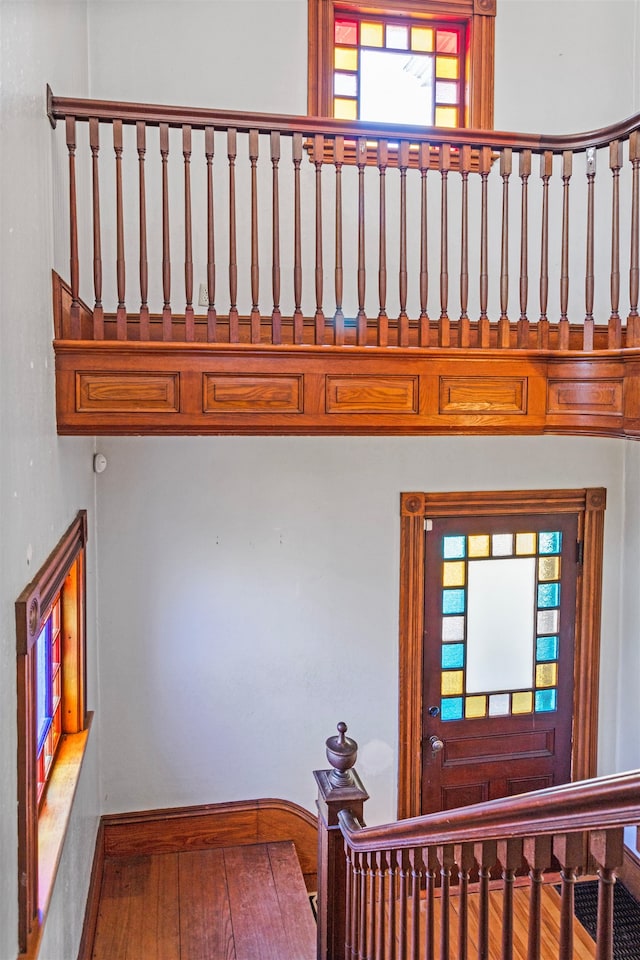 stairway featuring plenty of natural light, baseboards, and wood finished floors