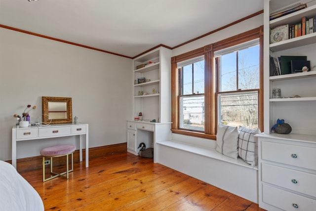 bedroom with baseboards, crown molding, and light wood-style floors