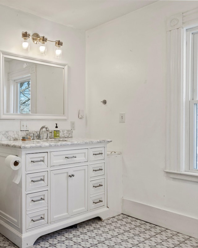 bathroom featuring tile patterned floors, baseboards, and vanity