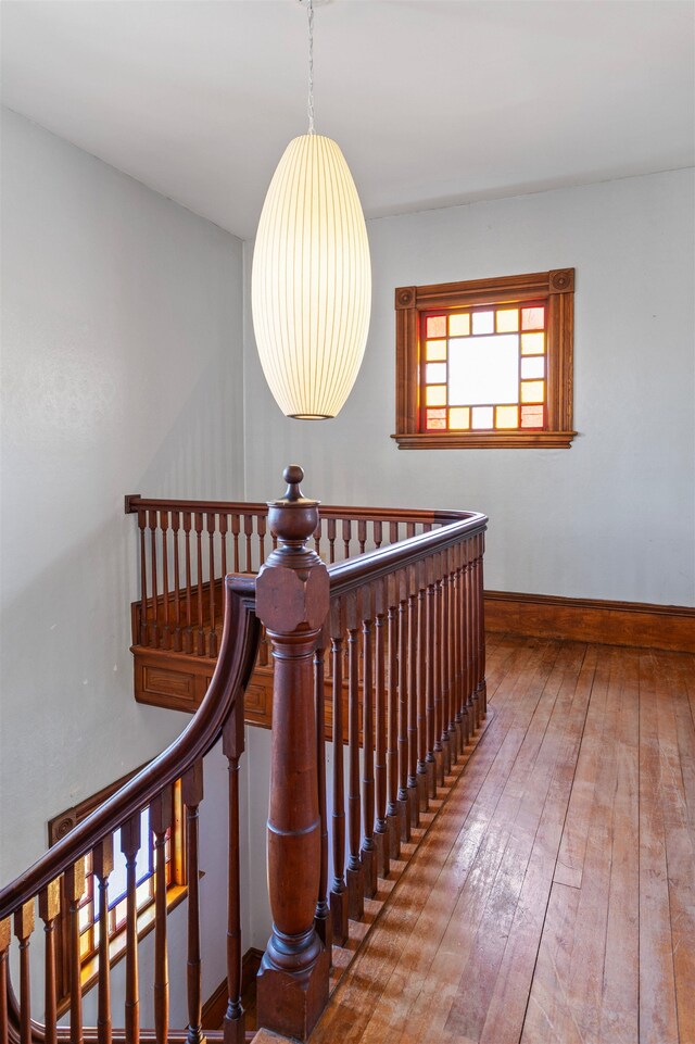 stairway featuring baseboards and hardwood / wood-style floors