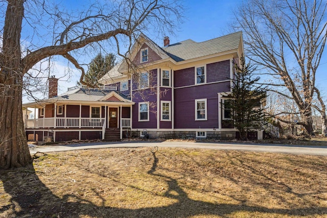 view of front of home featuring covered porch and a chimney