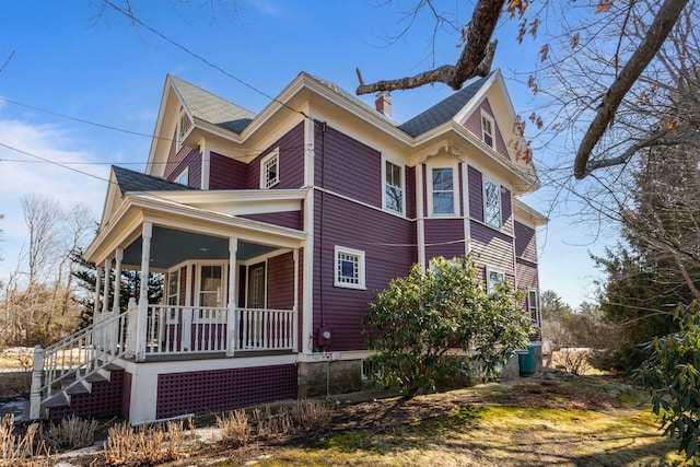 view of side of property featuring a porch and a chimney