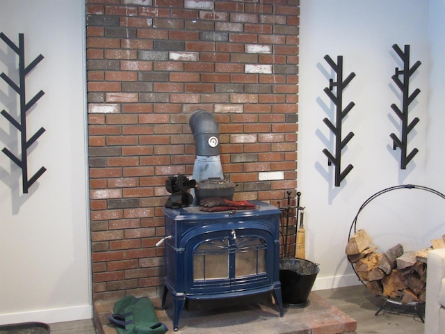 interior details featuring a wood stove, baseboards, and wood finished floors