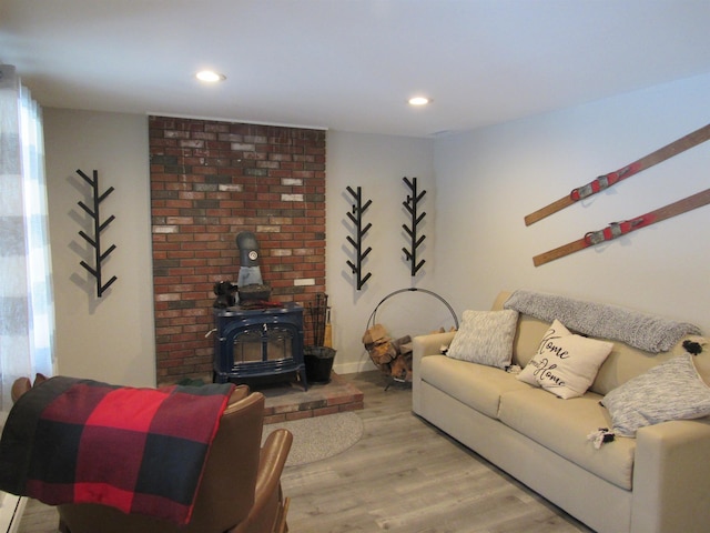 living area featuring a wood stove, recessed lighting, wood finished floors, and baseboards