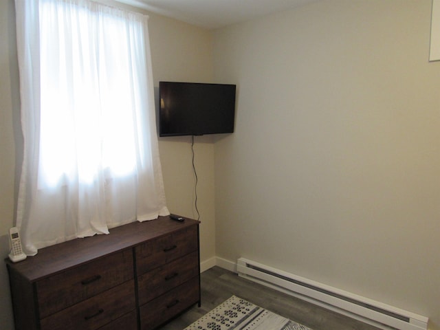 bedroom with a baseboard radiator, baseboards, and dark wood-style flooring