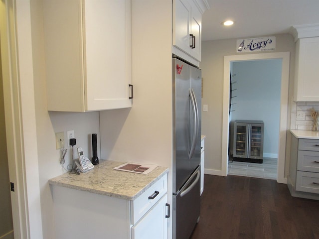 kitchen featuring white cabinetry, dark wood-type flooring, wine cooler, and freestanding refrigerator