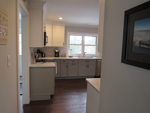 kitchen featuring a sink, tasteful backsplash, dark wood-style floors, recessed lighting, and dishwasher