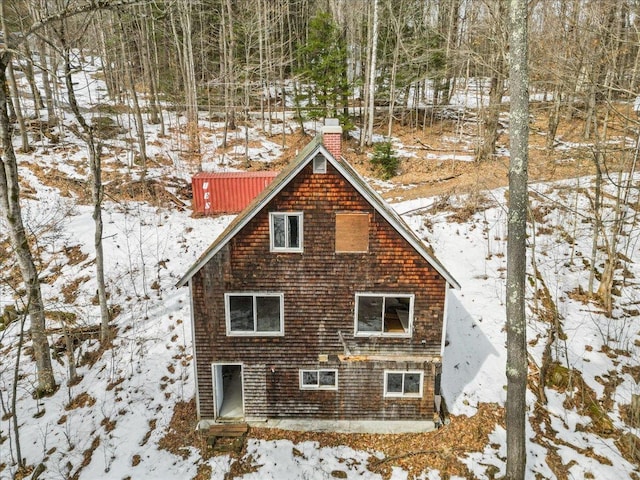 snow covered property featuring a chimney