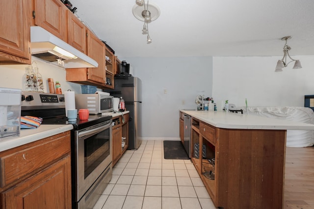 kitchen featuring light tile patterned flooring, a sink, light countertops, appliances with stainless steel finishes, and under cabinet range hood