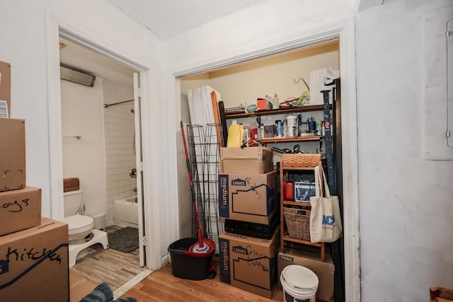 bathroom featuring toilet, wood finished floors, and washtub / shower combination