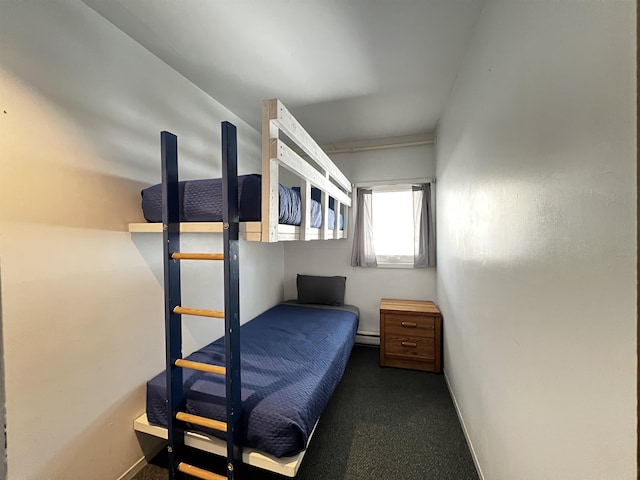 carpeted bedroom featuring a baseboard heating unit and baseboards