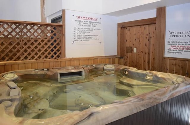 room details featuring wood walls and a hot tub