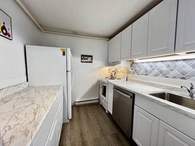 kitchen featuring dark wood-type flooring, baseboard heating, decorative backsplash, white appliances, and a sink