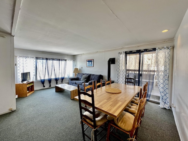 carpeted dining space featuring a wood stove