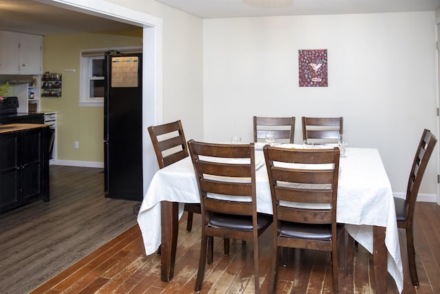 dining area with dark wood-style floors and baseboards