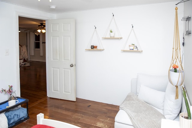 living area with wood finished floors and a ceiling fan