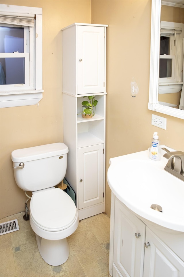 bathroom featuring visible vents, toilet, and vanity