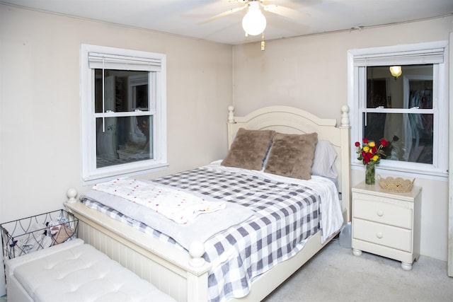 bedroom with light carpet and a ceiling fan