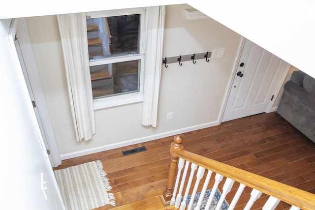 entryway with wood finished floors, visible vents, and baseboards