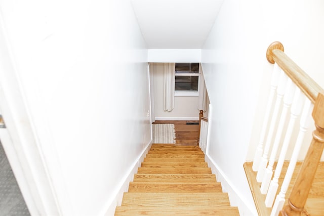 stairway with visible vents and wood finished floors