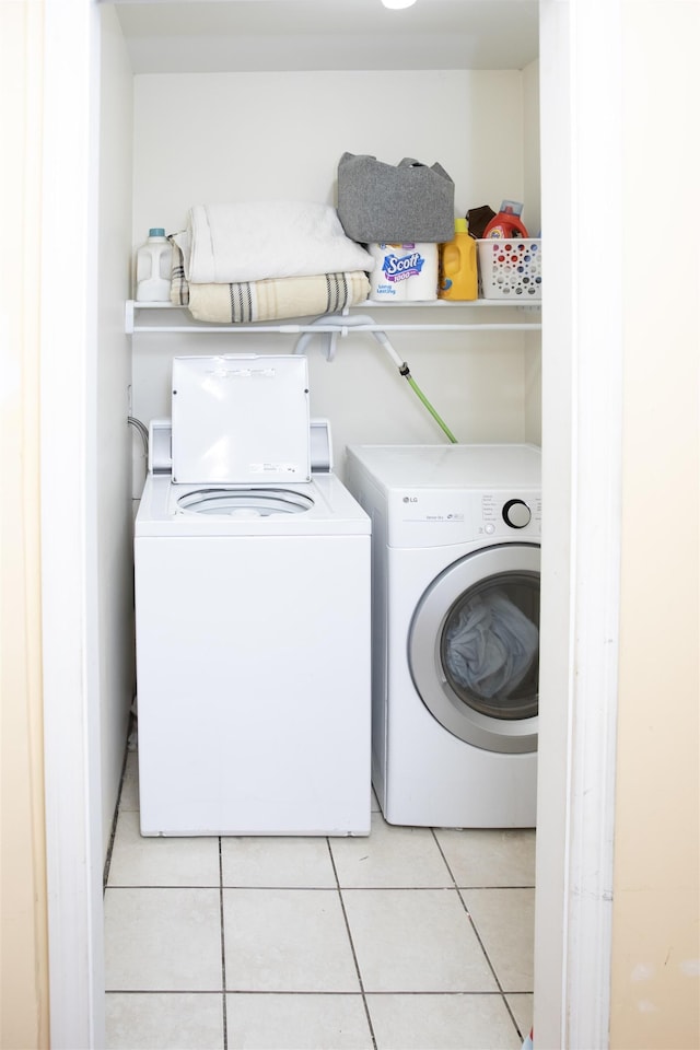 washroom with washer and dryer, light tile patterned flooring, and laundry area