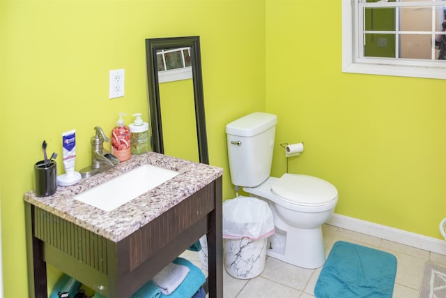 half bathroom with baseboards, toilet, vanity, and tile patterned flooring