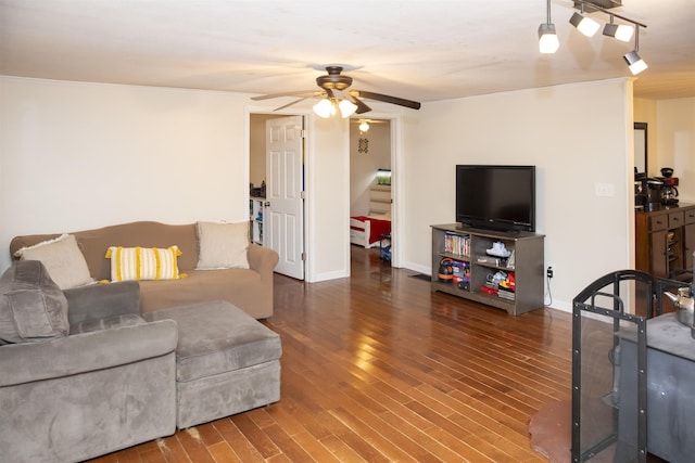 living room featuring track lighting, baseboards, ceiling fan, and wood finished floors