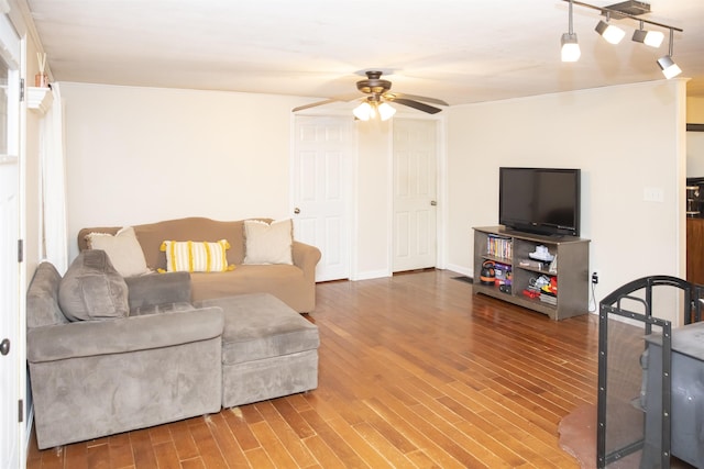 living room with track lighting, wood finished floors, and ceiling fan