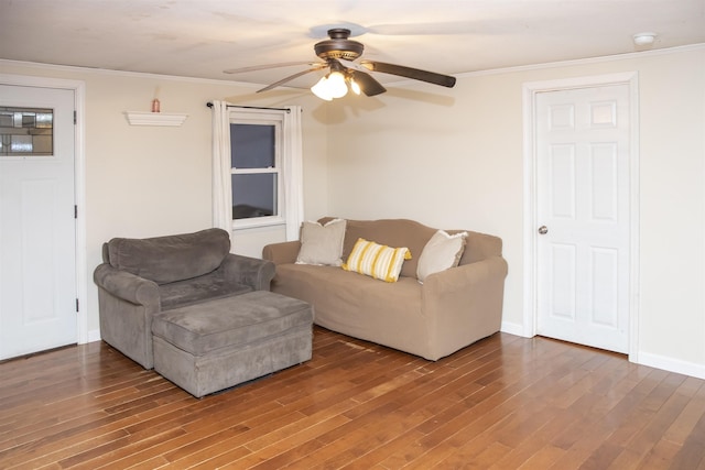 living area featuring ornamental molding, baseboards, a ceiling fan, and wood finished floors